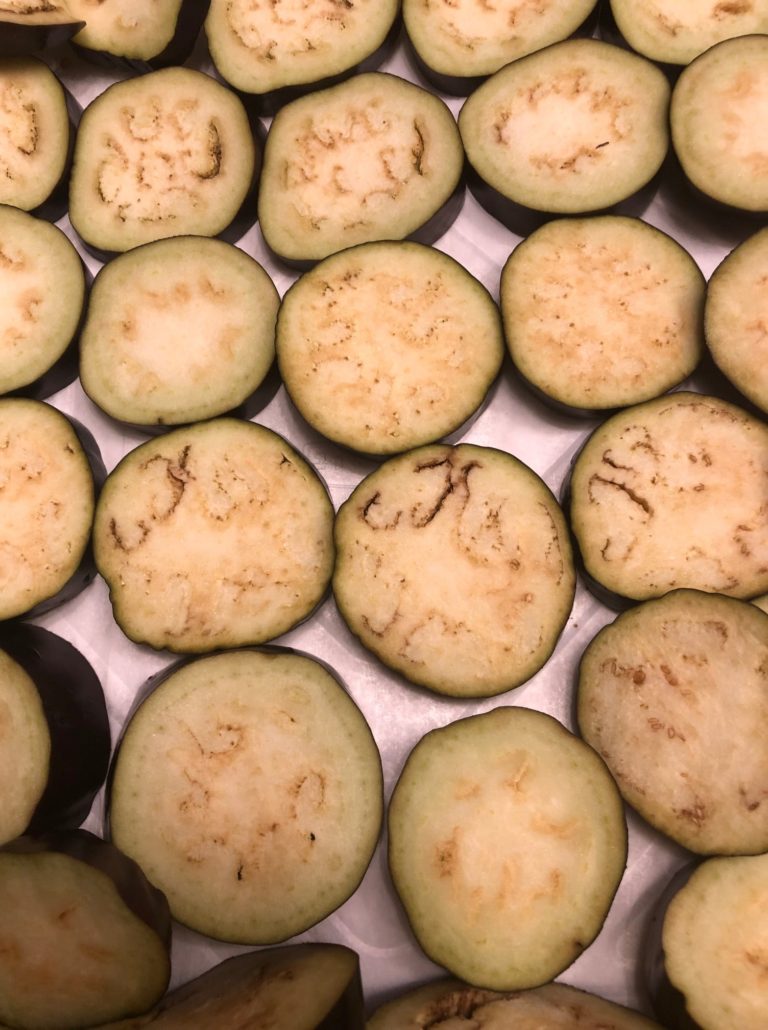 Sliced rounds of eggplant on a sheet pan