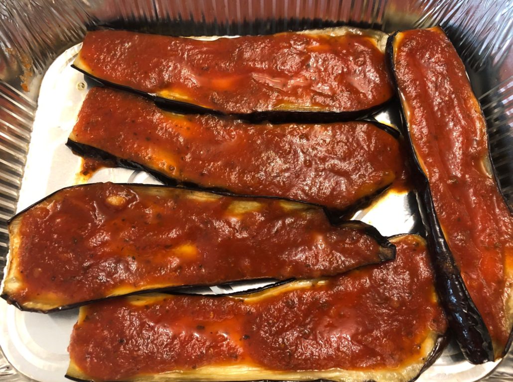 tomato sauce spread on browned eggplant