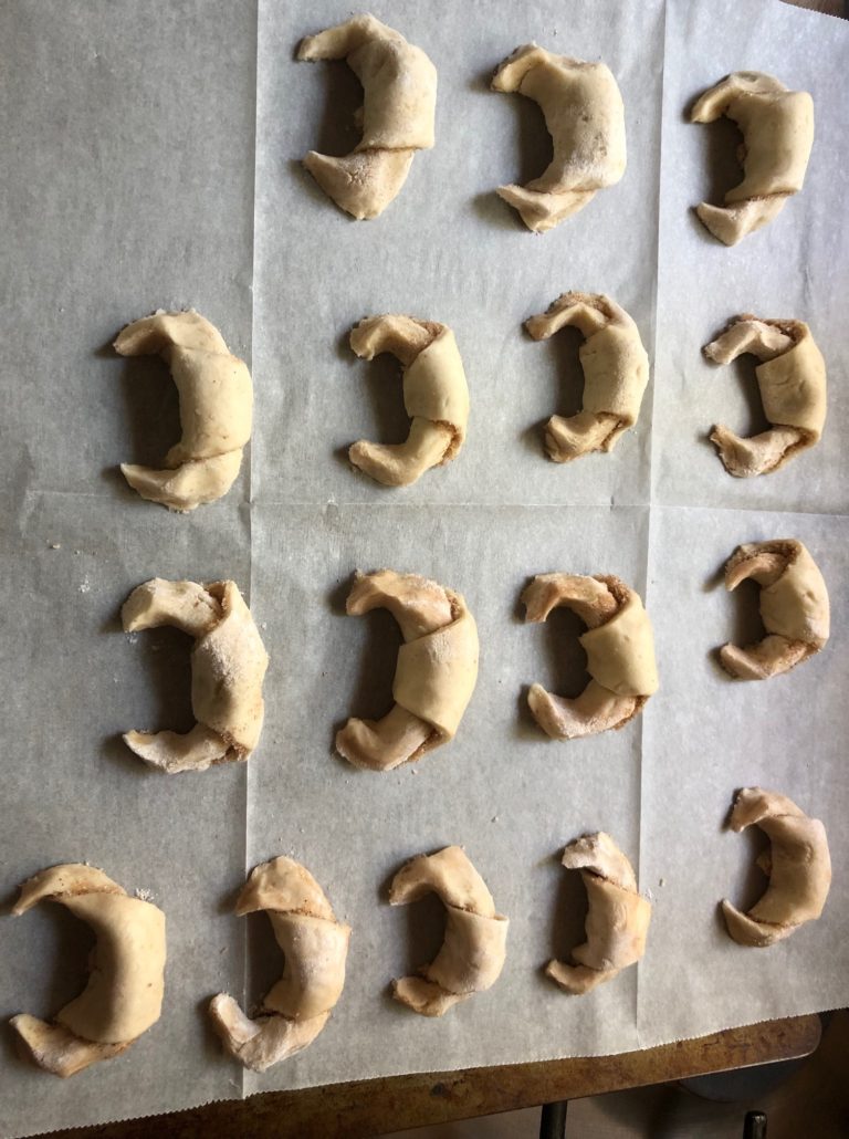 Rolled Rugelach on parchment paper on cookie sheet