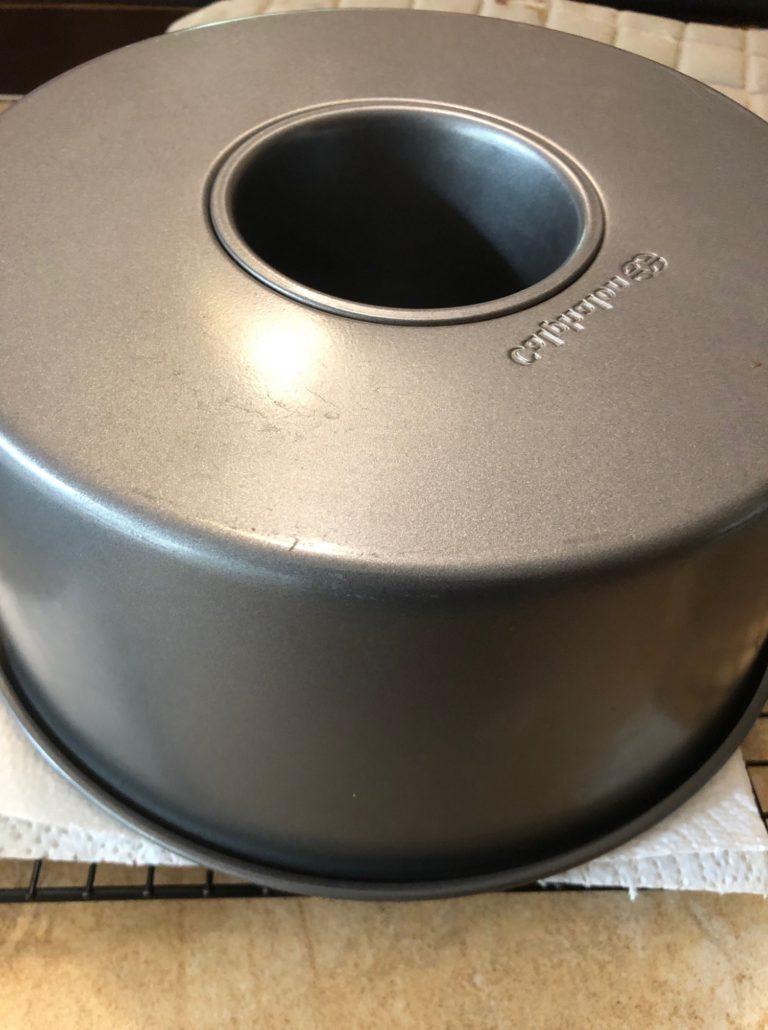 inverted chiffon cake on paper towel on cooling rack