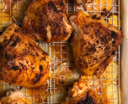 Paprika thyme honey drizzled chicken thighs with potatoes in drippings