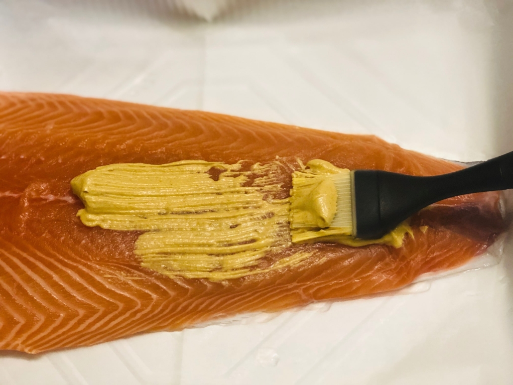 Spreading dijon mustard on fillet