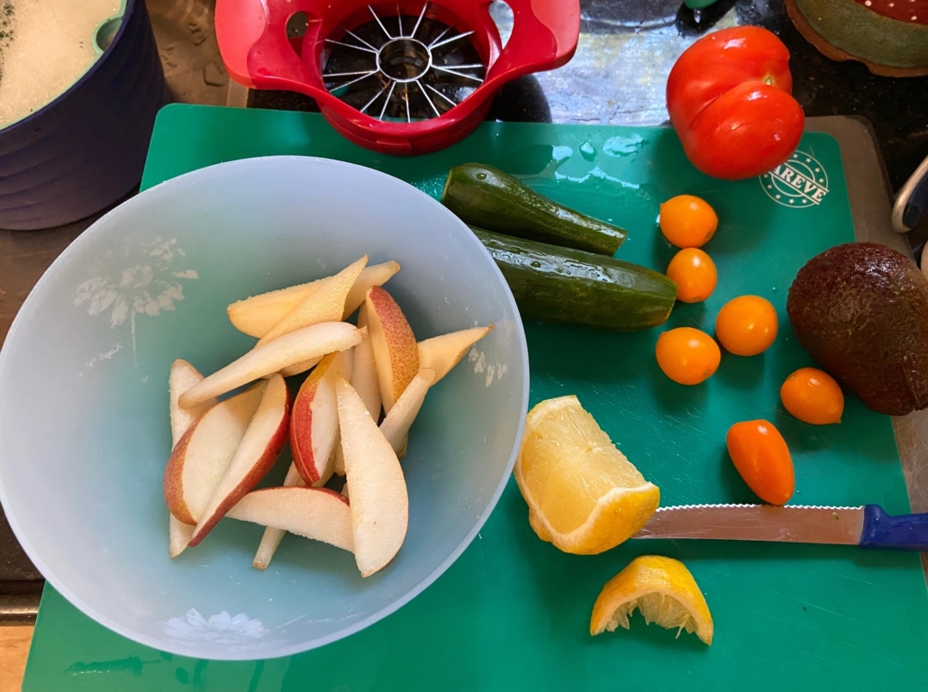Scrubbed veggies and sliced pear in lemon juice