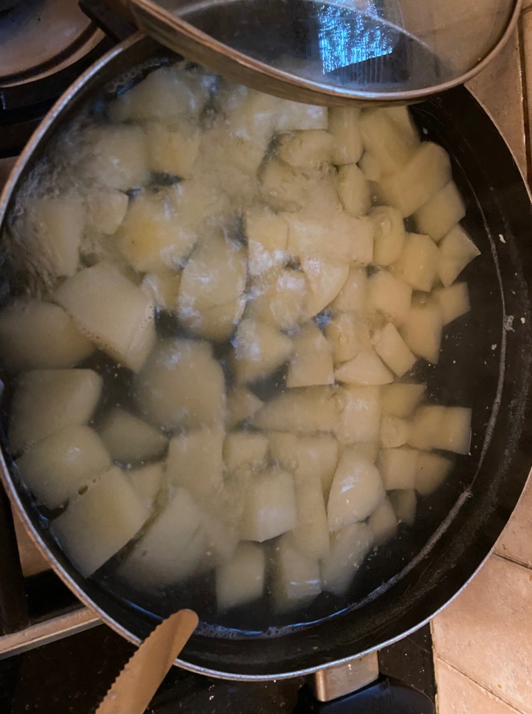 cubed peeled potatoes in boiling water