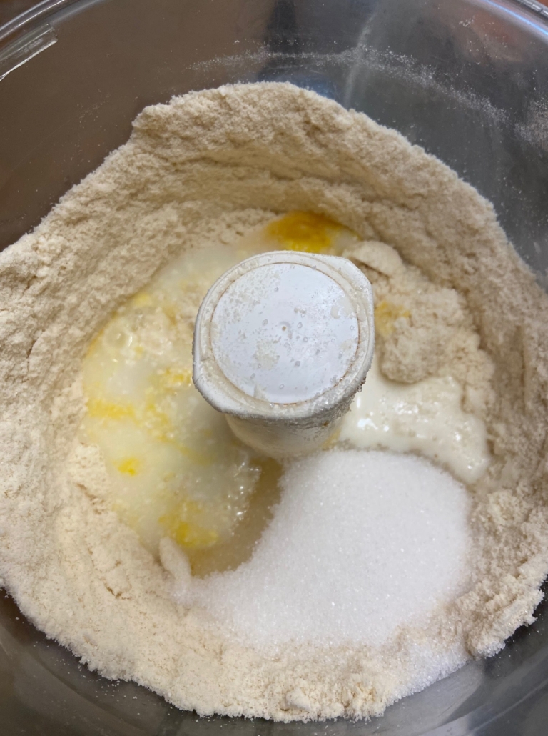 adding milk and eggs to mix with sugar