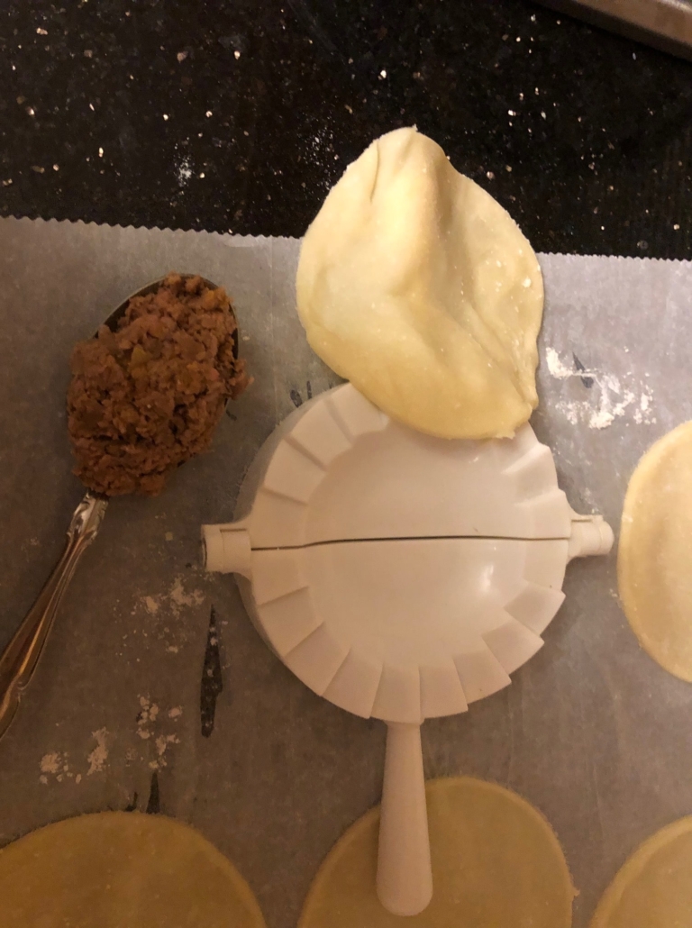 taking your teaspoon of filling and putting dough on gadget