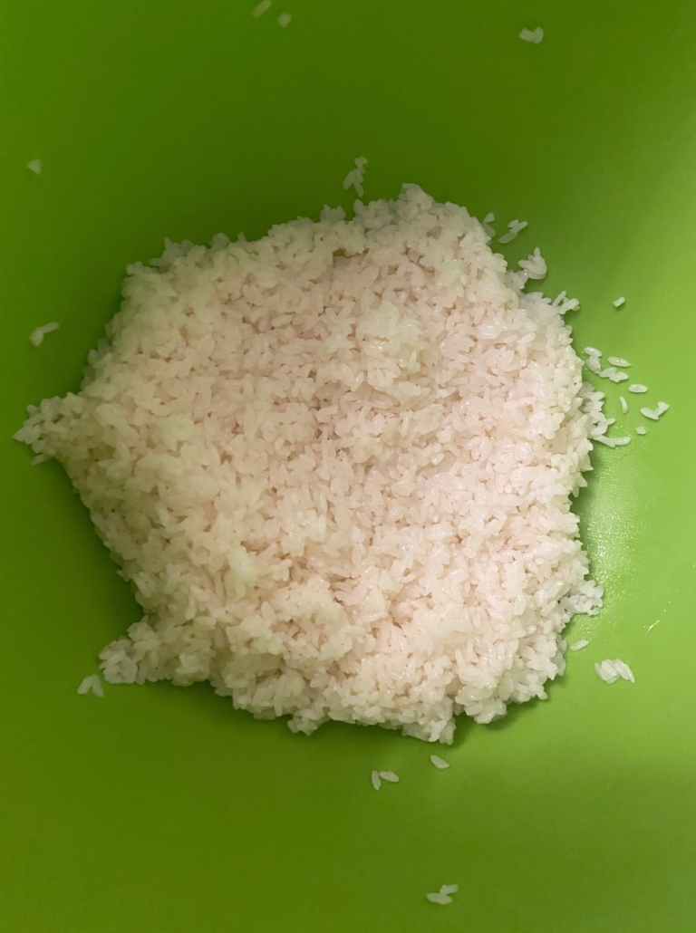 Stirring sushi rice with vinegar mix