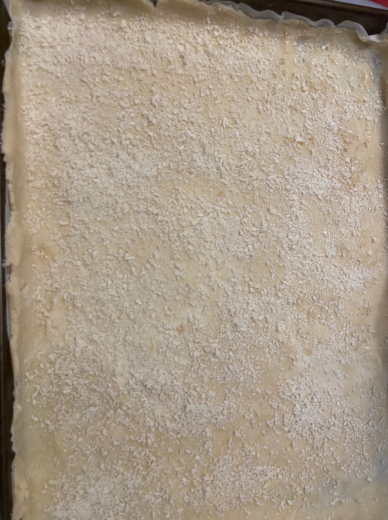 dough fitted in pan with breadcrumbs sprinkled on it