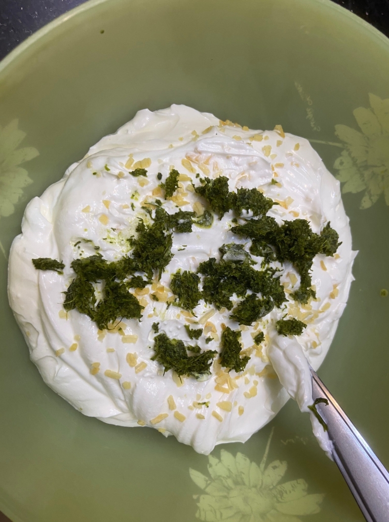 mixing the dill and onion into the sour cream