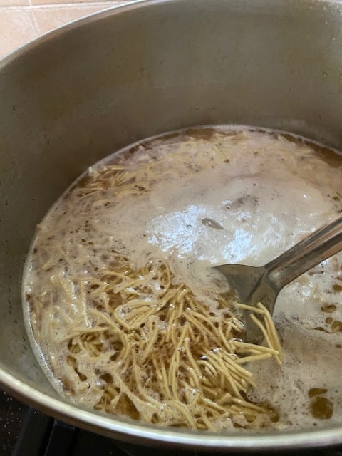 adding noodles to boiling liquid