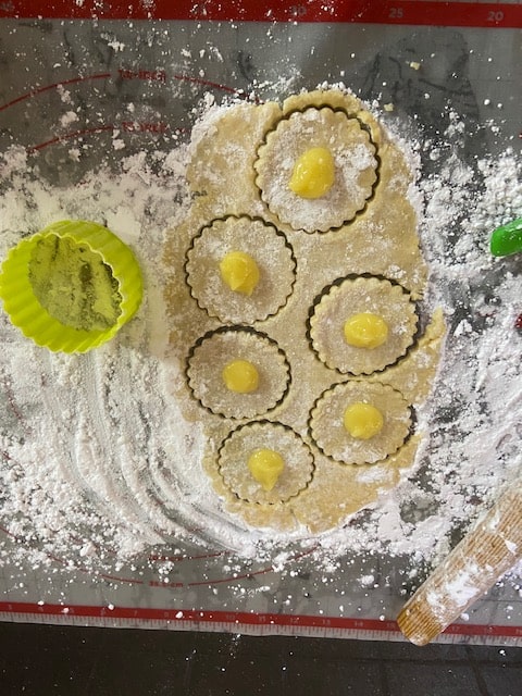 cutting out hamantaschen and dolloping filling