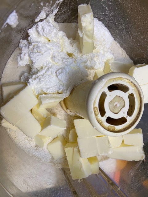 adding butter sour cream and cream cheese to flour mixture