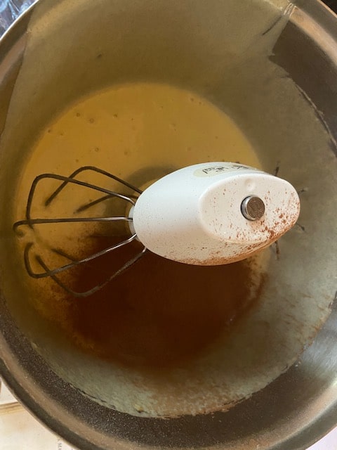 adding cocoa to cup of batter
