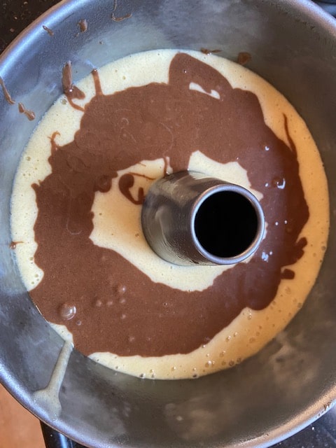cocoa batter on white batter in a circle