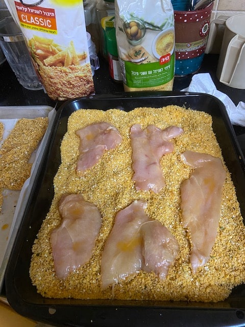 putting shnitzels in breadcrumbs