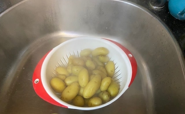 draining the potatoes