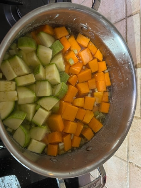 Adding veggies to the chicken stock
