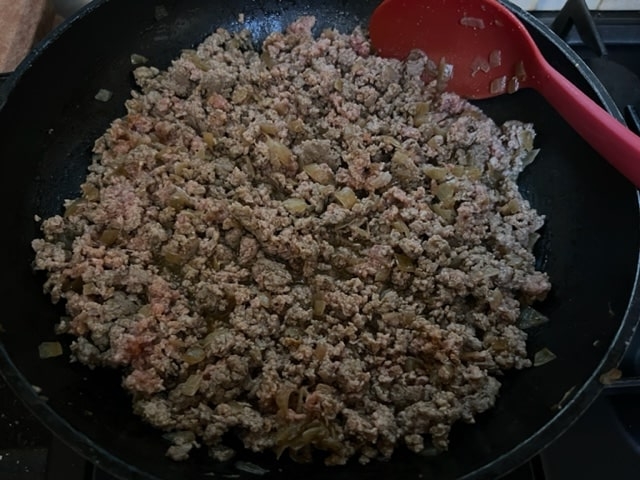 sauteeing the chopped beef with onion and spices