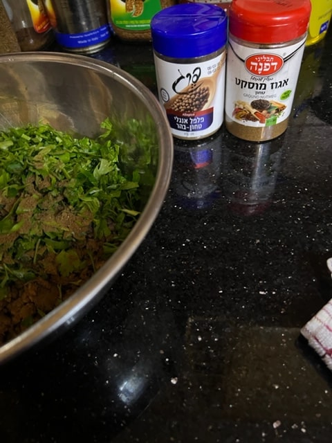 adding allspice and nutmeg with parsley to meat