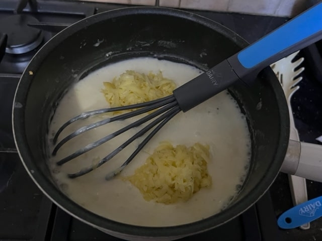 adding the cheese to the white sauce