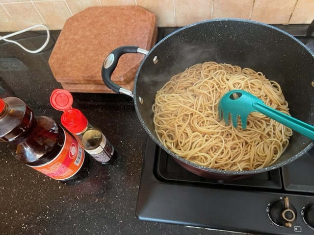 tossing spaghetti with oil
