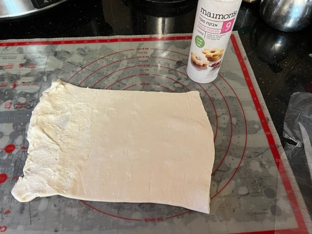 lay puff pastry on sugar on mat