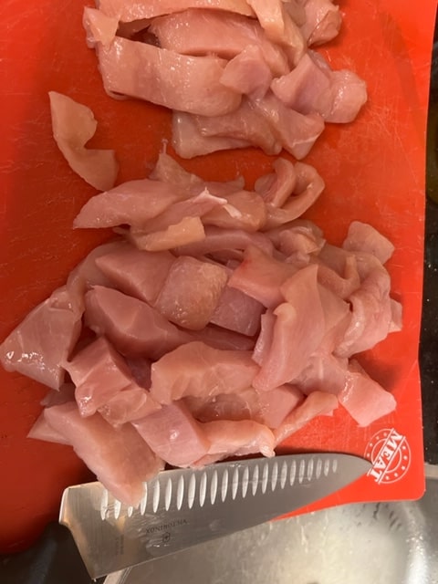 cutting the chicken breasts in chunks