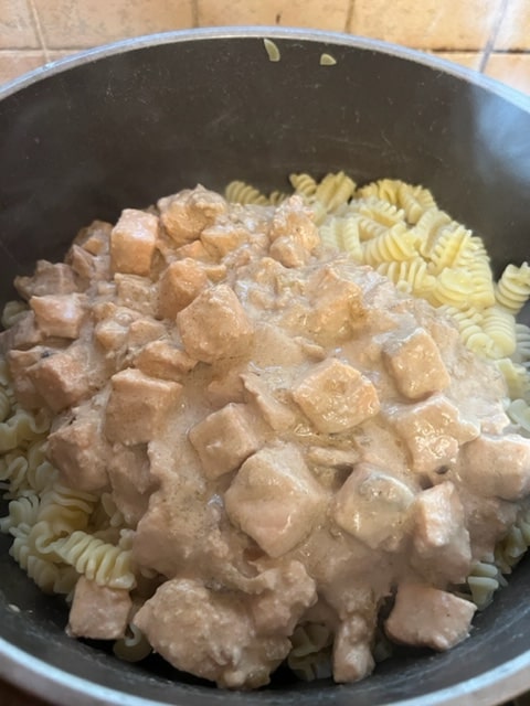 pouring the sauce on the pasta