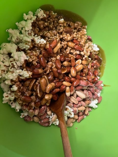 Pouring caramel over popcorn and peanuts