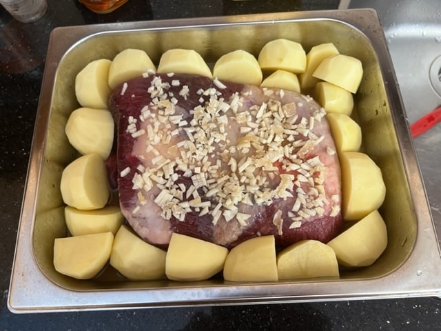 tucking the potatoes around the meat