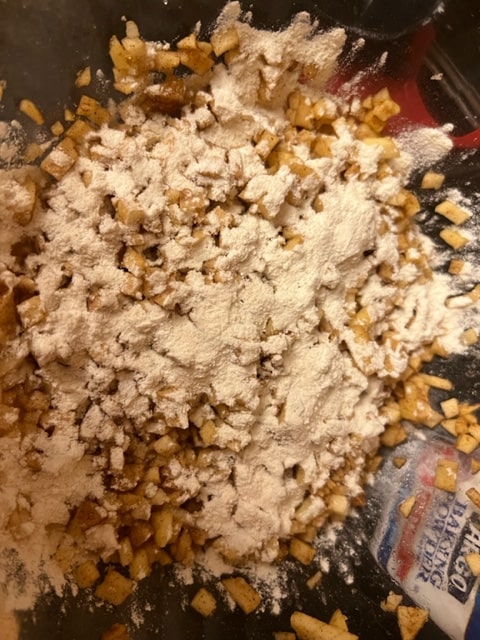 adding the flour to the apples