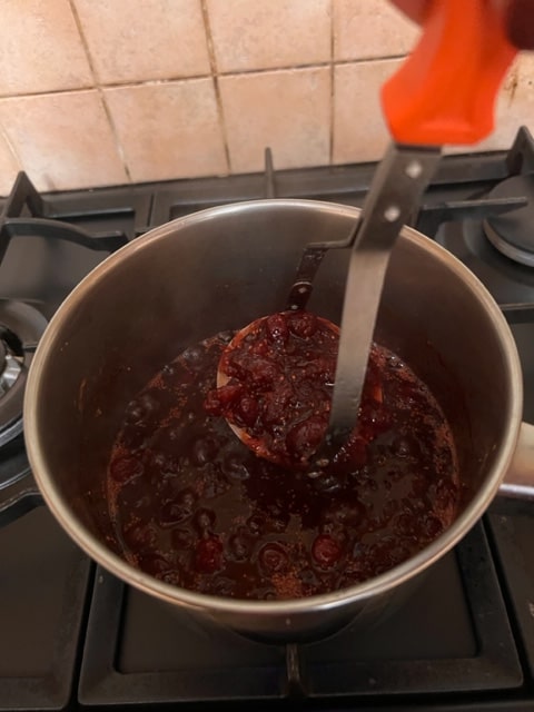 mashing the sauce with a potato masher