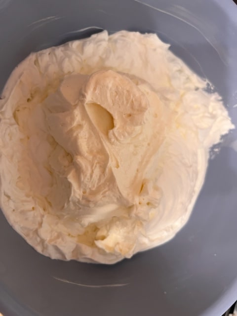 adding cream cheese mixture to whipped cream