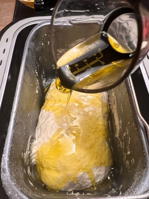 pouring second lot of oil over dough 