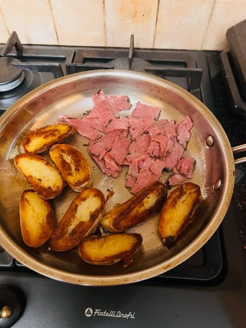 sauteeing the other side of the potatoes with the pastrami