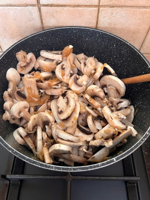 cooking the mushrooms with the onion