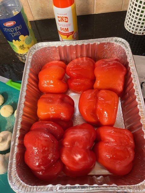 Oiled pepper halves in oiled pan, cut side down