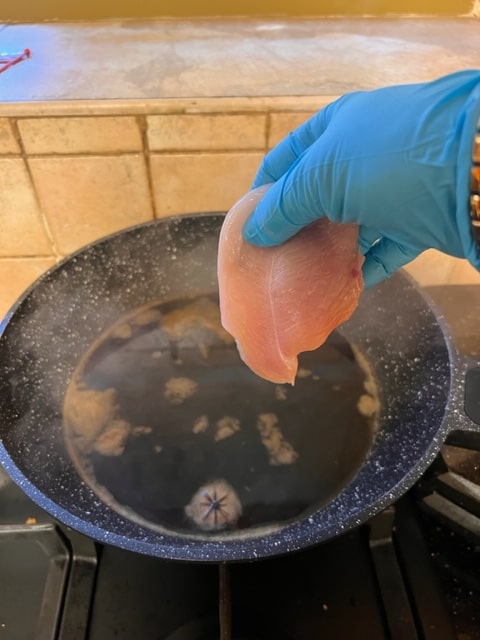 lower chicken breasts into simmering liquid