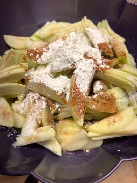 adding cornstarch and spices to apples and lemon juice