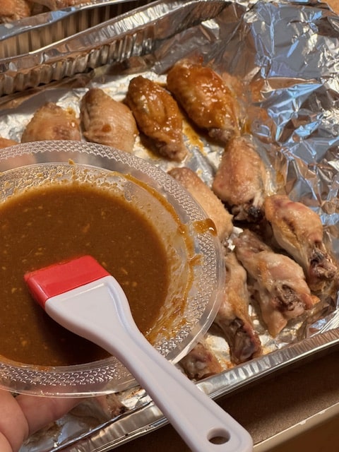 brushing sauce on wings