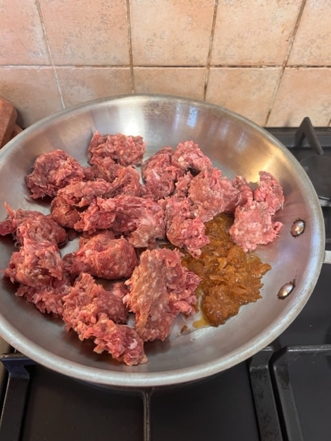 chopped meat with sauteed onion in pan