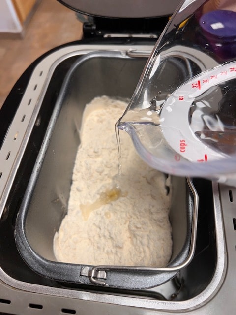 Adding the rest of the water to the flour, salt and yeast mixture