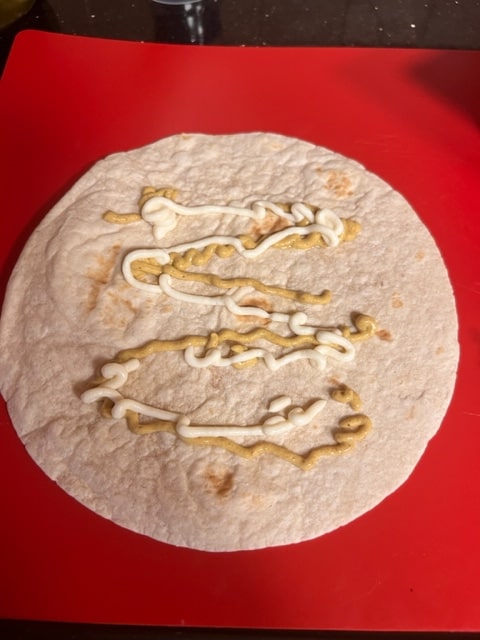 drizzling the mayo and mustard