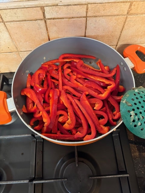 adding peppers to pan