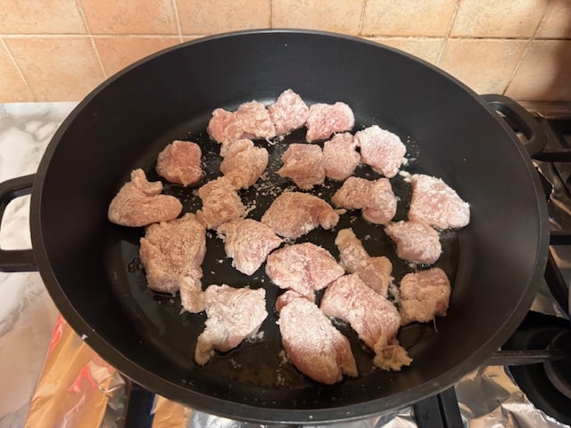 sauteeing the coated chicken pieces