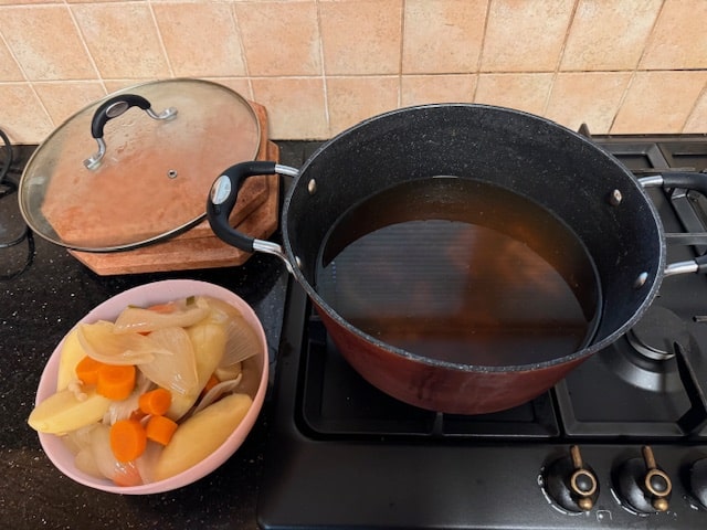 broth in pot, veg on the side