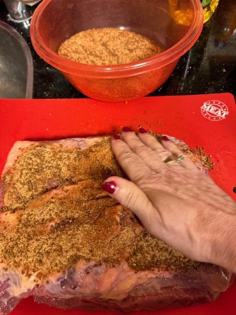 rubbing the dry rub into the brisket