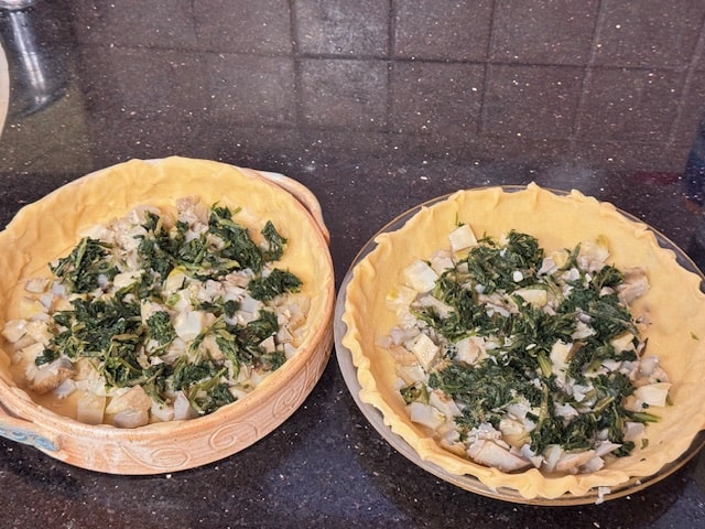 evenly distributing the spinach and artichokes in the pans
