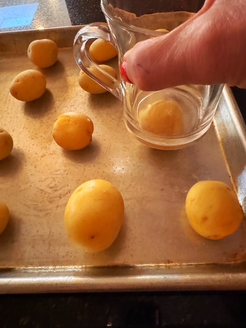 potatoes on baking sheet - beginning the smash