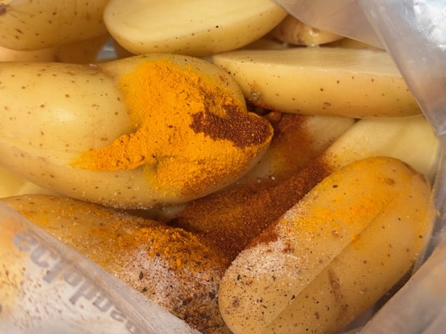 spices and olive oil in ziplock with potatoes